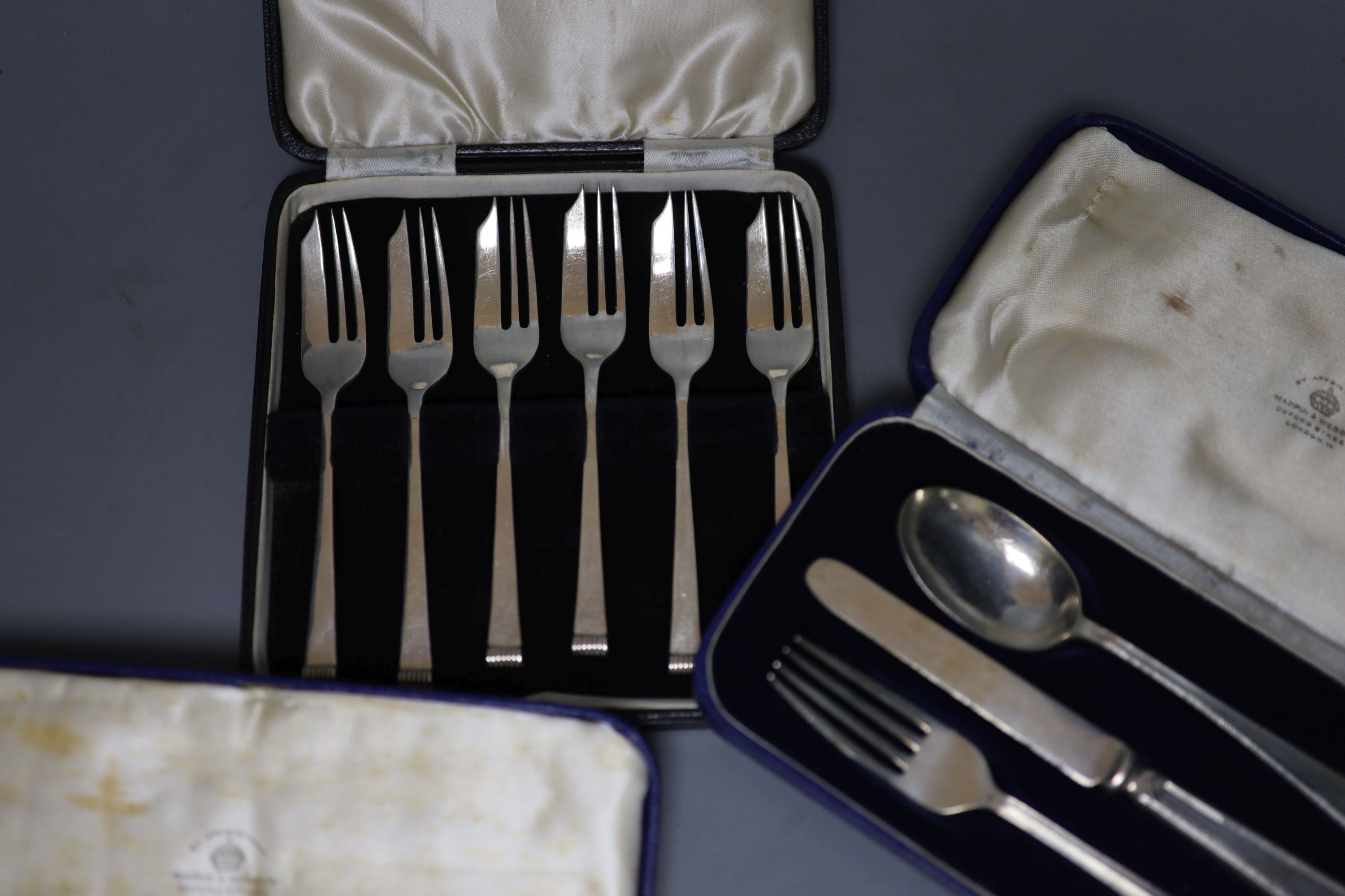 A cased set of six Art Deco silver cake forks, Sheffield, 1936 and two cased silver christening trios.